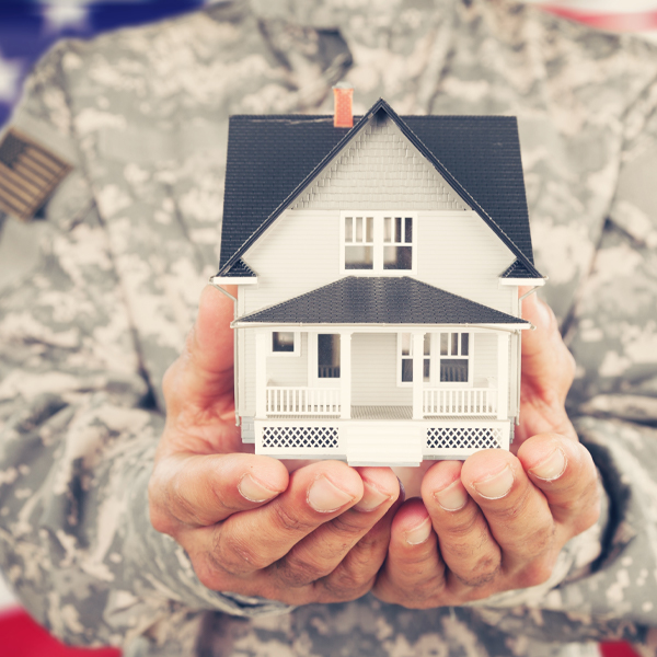 Soldier holding miniature house in hands